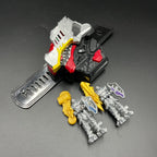 May include: A silver, red, and black dinosaur-shaped toy with a yellow and black head. Two gray knight figures with gold weapons and shields stand on either side. The shield has a red and black design. The dinosaur toy is on a clear stand.