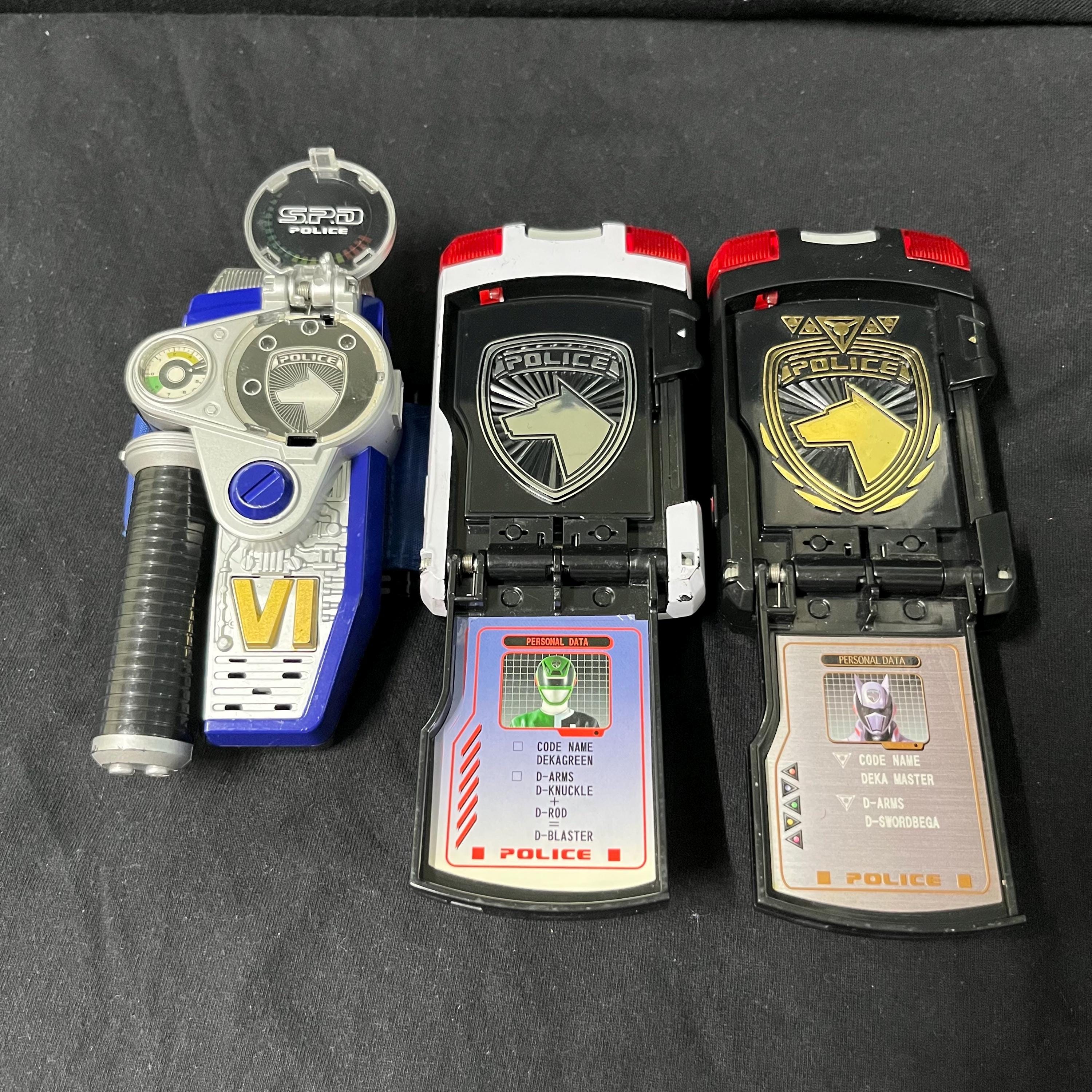 Transformation devices from Power Rangers S.P.D. and Dekaranger including Delta Morphers, Red Ranger Morpher, SPD Licenses, Dekamaster License, Patrol Morpher, and Morpher SPD.